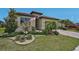 A well-manicured front yard with green grass, landscaping, and brick paver driveway at 20542 Trattoria Loop, Venice, FL 34293