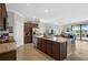 Open kitchen featuring a granite island, stainless steel appliances, and dark wood cabinets at 20542 Trattoria Loop, Venice, FL 34293