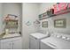 Functional laundry room with a utility sink, washer and dryer, and wall storage at 20542 Trattoria Loop, Venice, FL 34293