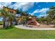 A sunny playground, with views of nearby buildings, beneath a partly cloudy blue sky at 20542 Trattoria Loop, Venice, FL 34293