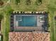 Aerial view of a screened-in pool and hot tub with a brick patio and lounge chairs at 20542 Trattoria Loop, Venice, FL 34293
