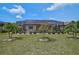 Lovely backyard view of screened pool enclosure surrounded by well-maintained landscaping at 20542 Trattoria Loop, Venice, FL 34293