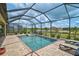 Outdoor pool and spa area with a screened enclosure and scenic landscaping views at 20542 Trattoria Loop, Venice, FL 34293