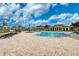 A gorgeous pool with brick floors and lounge chairs beneath a partly cloudy blue sky at 20542 Trattoria Loop, Venice, FL 34293