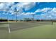 A wonderful tennis court beneath a partly cloudy blue sky at 20542 Trattoria Loop, Venice, FL 34293