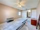 Bedroom featuring beige walls, a ceiling fan, a window, and an en-suite bathroom at 2188 Corinne S Ct # A, St Petersburg, FL 33712