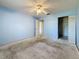 Bedroom with blue walls, ceiling fan, closet, and doorway at 2188 Corinne S Ct # A, St Petersburg, FL 33712