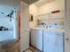 Laundry room equipped with white washer and dryer, wire shelves, and access to a different room at 2188 Corinne S Ct # A, St Petersburg, FL 33712
