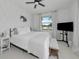 Bright bedroom features a ceiling fan and a window overlooking a peaceful outdoor scene at 22803 67Th E Ave, Bradenton, FL 34211