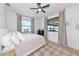 Bright bedroom with windows showcasing outdoor views, features a ceiling fan and neutral tones at 22803 67Th E Ave, Bradenton, FL 34211