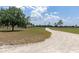 Long private driveway leading to a picturesque home, surrounded by lush greenery, ensuring privacy and tranquility at 22803 67Th E Ave, Bradenton, FL 34211