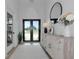 Bright foyer featuring double glass doors, light wood floors, white console table, and a large round mirror at 22803 67Th E Ave, Bradenton, FL 34211