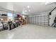 Spacious garage featuring speckled epoxy flooring, tall shelving, with bright lighting and ample room for vehicles at 22803 67Th E Ave, Bradenton, FL 34211