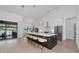 Open kitchen with island, stylish pendant lights, stainless steel appliances, and sliding doors to covered patio at 22803 67Th E Ave, Bradenton, FL 34211