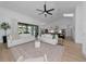 Open-concept living room featuring white sofas, large rug, and seamless access to the kitchen and outdoor area at 22803 67Th E Ave, Bradenton, FL 34211