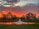 Tranquil pond with fountain reflecting a vibrant sunset, creating a serene and scenic view at 22803 67Th E Ave, Bradenton, FL 34211