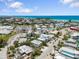 Aerial shot showcasing community homes near white sandy beaches and blue ocean at 229 S Harbor Dr, Holmes Beach, FL 34217