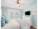 Airy bedroom featuring balcony access, ceiling fan, and ocean-themed décor at 229 S Harbor Dr, Holmes Beach, FL 34217