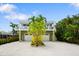 Attractive two-story home featuring a white balcony, dual garage doors, and tropical landscaping at 229 S Harbor Dr, Holmes Beach, FL 34217