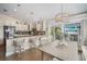 Bright kitchen featuring custom cabinets, an island with seating, and an adjacent dining area overlooking the water at 229 S Harbor Dr, Holmes Beach, FL 34217