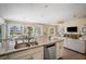 Open-concept kitchen and living area featuring a large island, stainless steel appliances, and water views at 229 S Harbor Dr, Holmes Beach, FL 34217