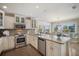 Well-appointed kitchen with an island, stainless steel appliances, custom cabinetry, and barstool seating at 229 S Harbor Dr, Holmes Beach, FL 34217