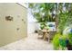 Stylish outdoor patio with decorative wall art, dining set, and lush tropical plants at 229 S Harbor Dr, Holmes Beach, FL 34217