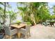 Charming patio area with a dining table, chairs, and a tranquil view of the pool at 229 S Harbor Dr, Holmes Beach, FL 34217