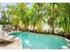 Private pool area featuring tropical landscaping and a brick-paved deck perfect for relaxation at 229 S Harbor Dr, Holmes Beach, FL 34217