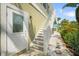 Side view of the home showcasing a private entrance and exterior staircase to the upper level at 229 S Harbor Dr, Holmes Beach, FL 34217
