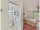 View of bathroom with a toilet and cabinet, connected to a bedroom with a bed and window at 2607 Lancaster Dr # 35, Sun City Center, FL 33573