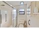 Bathroom with a toilet, shower, cabinet, window, grab bars, and bright lighting at 2607 Lancaster Dr # 35, Sun City Center, FL 33573