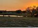 Scenic community view with a tranquil pond, mature trees, and wading birds under a beautiful sunset sky at 2607 Lancaster Dr # 35, Sun City Center, FL 33573
