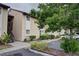 Exterior of a two-story condo building with neutral stucco, a staircase, and landscaping at 2616 Hidden Lake N Dr # A, Sarasota, FL 34237
