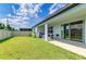 Grassy backyard with covered patio and sliding glass doors at 2926 61St E Dr, Ellenton, FL 34222