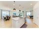 Open-concept kitchen featuring a center island with seating, stainless steel appliances, and modern pendant lighting at 2926 61St E Dr, Ellenton, FL 34222