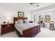Bright bedroom with a wood-trimmed bed, a ceiling fan, and an exterior view of a well-kept yard with palm trees at 315 Heritage Isles Way, Bradenton, FL 34212