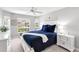 Bright bedroom with white furniture, a large window showcasing the neighborhood, and a comfortable blue bed at 315 Heritage Isles Way, Bradenton, FL 34212
