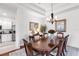 Formal dining room with rich wood floors, a decorative chandelier, and adjacent kitchen view at 315 Heritage Isles Way, Bradenton, FL 34212