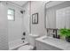 Bright bathroom featuring tub with shower, modern vanity, and contemporary black accents at 3193 Bellevue St, Sarasota, FL 34237