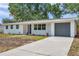 Charming single-story home featuring a gray garage door and fresh landscaping at 3193 Bellevue St, Sarasota, FL 34237