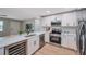 Modern kitchen with stainless steel appliances, white cabinets, quartz countertops, and hardwood floors at 3193 Bellevue St, Sarasota, FL 34237
