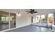 Enclosed patio featuring a ceiling fan, gray flooring, and slider doors opening to the home interior at 3193 Bellevue St, Sarasota, FL 34237