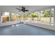 Enclosed patio with gray floor, and screen windows looking out to a fenced yard with mature trees at 3193 Bellevue St, Sarasota, FL 34237
