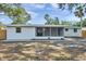 Backyard view of home featuring a screened lanai, freshly painted exterior, and landscaping potential at 3193 Bellevue St, Sarasota, FL 34237