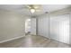 Bedroom with wood-look floors, ceiling fan, and a closet offers ample space for relaxation at 3263 Woodberry Ln # Lot 15, Sarasota, FL 34231