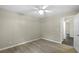 Bedroom with wood-look floors, ceiling fan, and ensuite bath offers ample space for relaxation at 3263 Woodberry Ln # Lot 15, Sarasota, FL 34231