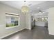 An dining room showing dark tile floors, a chandelier, and adjoined kitchen at 3263 Woodberry Ln # Lot 15, Sarasota, FL 34231