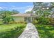 Well-maintained home with lush landscaping and a walkway leading to the entrance at 3263 Woodberry Ln # Lot 15, Sarasota, FL 34231