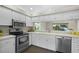 Well-lit kitchen featuring stainless steel appliances and white cabinets at 3263 Woodberry Ln # Lot 15, Sarasota, FL 34231